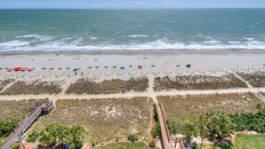 A beach with umbrellas and a boardwalk. - Camelot By the Sea 1111 - Remodeled Spring 2023 - 2 Bed/2 Bath (Myrtle Beach)