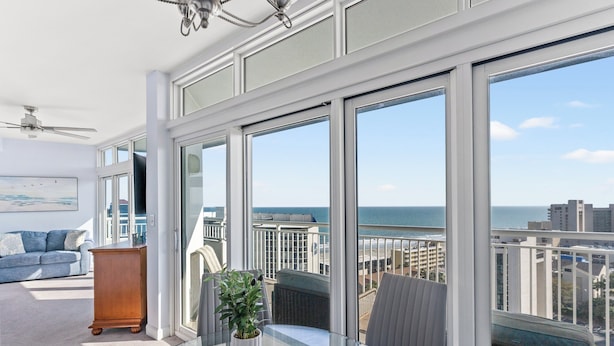 A balcony with a glass table, a potted plant, and a view of the ocean. - Horizon Penthouse 18, Lovely Condo in Myrtle Beach (Myrtle Beach)