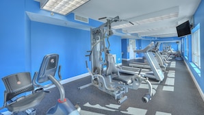 A gym with exercise equipment, a treadmill, and a mirror. - Horizon Penthouse 18, Lovely Condo in Myrtle Beach (Myrtle Beach)