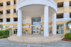Welcome to the hotel, featuring a modern entrance with a central entrance flanked by columns and potted plants.