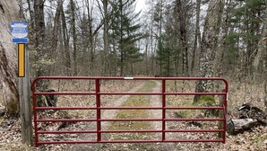 A gated entrance with a sign for Brooks Security Systems. - Perfect Getaway! Secluded Modern 3 Bedroom, 2 Bath Cabin on 12.5 Private Acres (Baldwin)