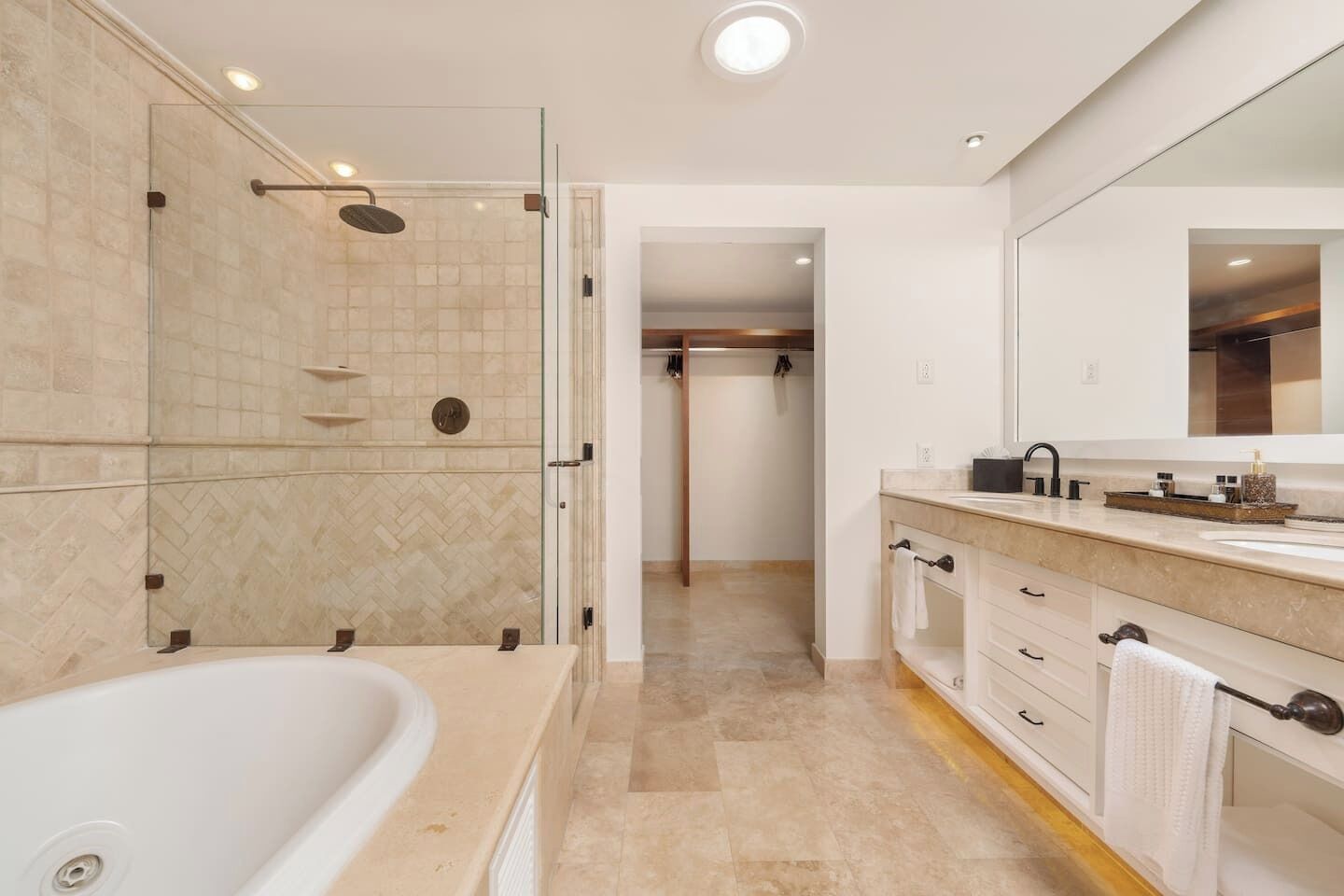 A modern bathroom with a glass-enclosed shower, a freestanding bathtub, and a vanity with a large mirror.