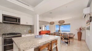 Eine moderne Küche mit Granit-Arbeitsplatten, Edelstahlgeräten und einer großen Kücheninsel mit Barhocker.