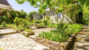 Un bâtiment en pierre avec un sentier de jardin menant à une maison en pierre.