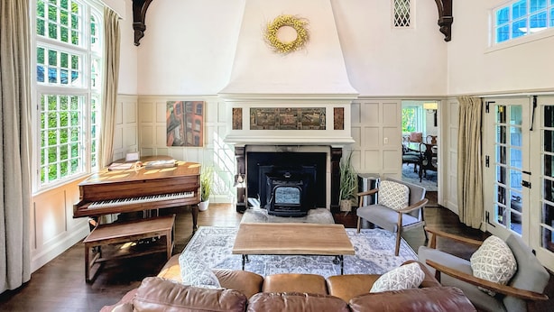A spacious living room with a piano, fireplace, and comfortable seating.