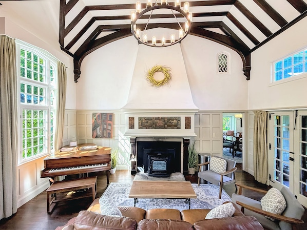 A spacious living room with a piano, fireplace, and comfortable seating.