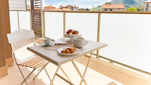 A balcony with a table set for breakfast, including croissants and pastries, and a chair. - Michelangelo - Borghetto Santo Spirito (Borghetto Santo Spirito)