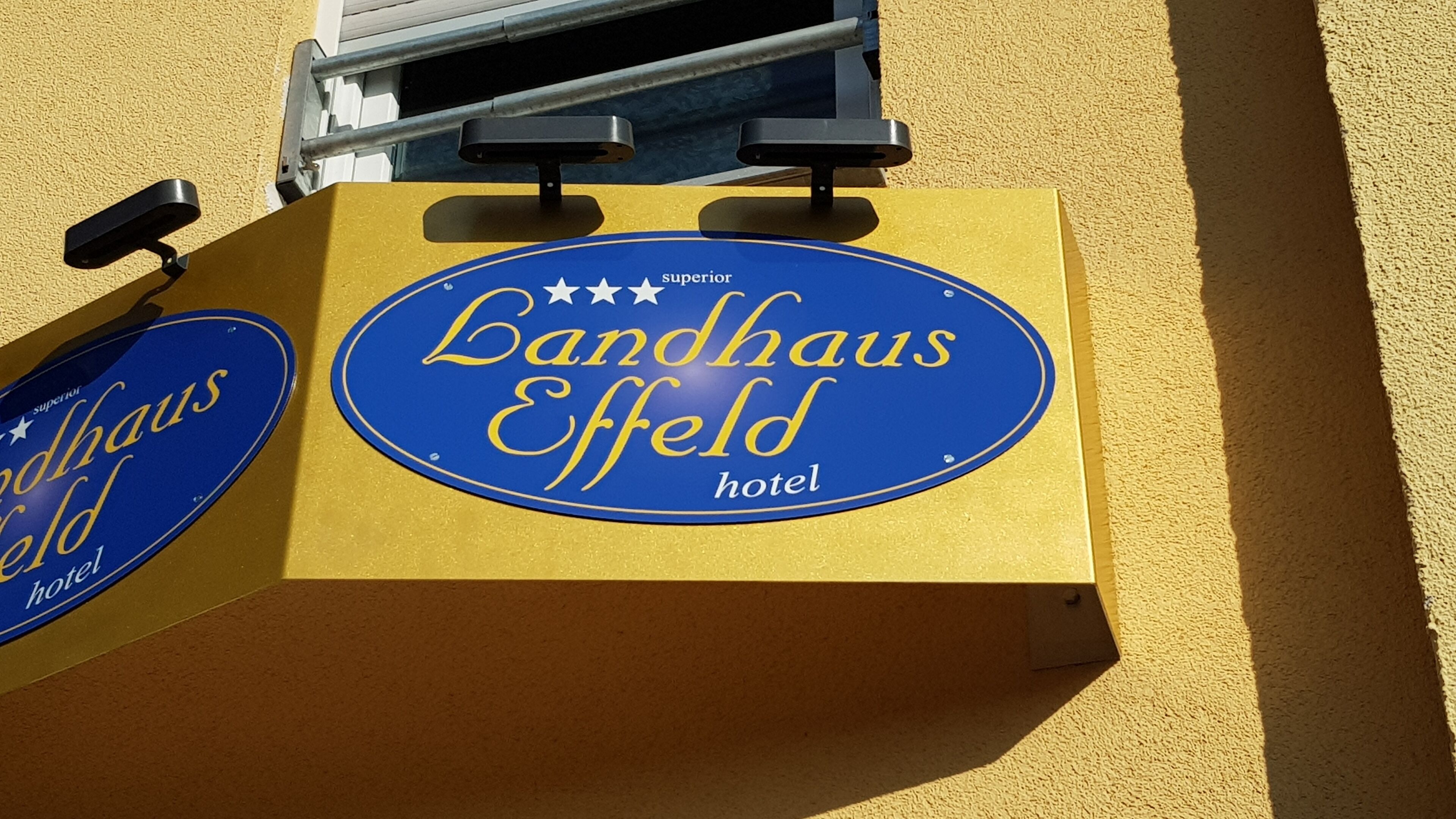 Señal para el hotel Landhaus Effeld, con una combinación de colores azul y dorado.