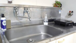 A stainless steel sink with two faucets, a soap dispenser, a soap bar, and a scale. - Hokusei Building 41 (Sapporo)