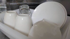 A white dish rack with various white ceramic items including cups and a bowl. - Hokusei Building 41 (Sapporo)