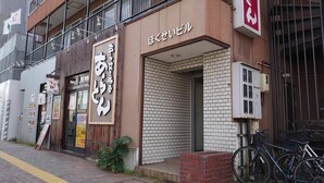 A building with a sign that reads "あおうあいぴぴ" and another sign that says "ほくせいぴぴ". There are bicycles parked outside and a small brick structure in front. - Hokusei Building 41 (Sapporo)