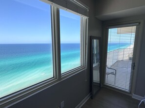 Una habitación con un ventanal grande con vista a una playa y al océano.