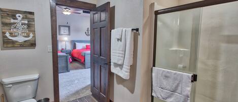 A bathroom with a toilet, a shower with a glass door, and a towel rack.