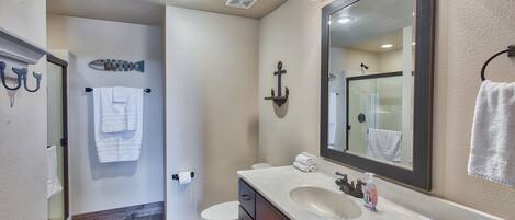 A bathroom with a white sink, a large mirror, and a towel rack.