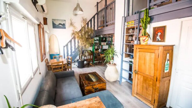 Una sala de estar acogedora con un sofá, una mesa de centro y un aparador de madera.