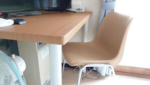 A wooden desk with a computer monitor, keyboard, and mouse. A beige chair is positioned at the desk. - Hokusei Building 42 (Sapporo)