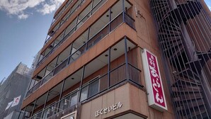 A multi-story building with balconies and a sign indicating a business or commercial use. - Hokusei Building 42 (Sapporo)
