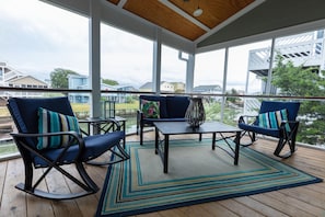 Relax in a serene outdoor space with a seating area featuring two rocking chairs and a small table.