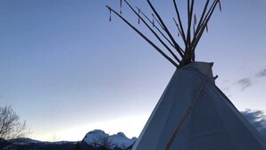 A tipi with a clear view of snow-capped mountains in the background. - Tepee at the Lama- & Alpakahof Triesenberg (Triesenberg)