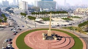 A cityscape with a central roundabout, surrounded by palm trees and modern buildings. - City Palace Hotel (Cairo)