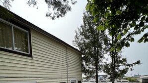 Un parque para vehículos recreativos frente al agua, con un edificio de una sola planta, un sendero de grava y un área de embarcadero.