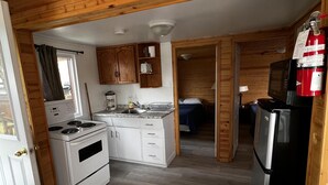 Una cocina compacta con armarios de madera, estufa, microondas y refrigerador.