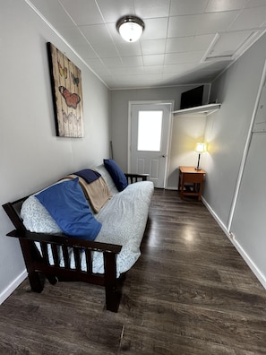 Cozy retreat with a single bed, table, and artwork featuring butterflies.