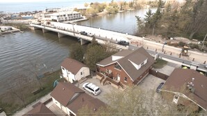 A residential area with houses, a bridge, and a body of water. - Dock Life Beach 1 - Unit 16, Riverside Property, 2 Bdrm, 3 min walk to Beach 1 (Wasaga Beach)