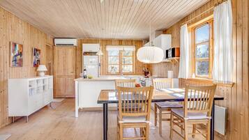 Un intérieur en bois comprenant un coin cuisine, une table à manger et des chaises.