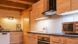 Une cuisine moderne avec des meubles en bois, un four encastré et un four à micro-ondes.
