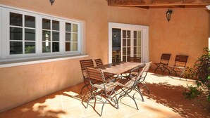 A patio with a wooden table and chairs, a window, and a door. - Lovely home in Fayence (Fayence)