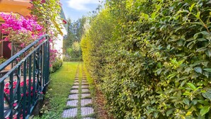 A garden pathway with a metal railing on one side and a hedge on the other. - Amazing apartment in Trecastagni with WiFi (Trecastagni)