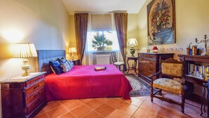 A hotel room with a large bed, a dresser, a chair, a desk, and a painting on the wall. - Amazing apartment in Trecastagni with WiFi (Trecastagni)