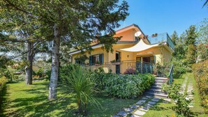 A two-story house with a balcony, surrounded by a well-maintained garden and a stone pathway leading to the entrance. - Amazing apartment in Trecastagni with WiFi (Trecastagni)
