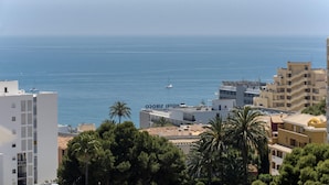 Vista sulla costa con un hotel chiamato "HOTEL SIRCO" in primo piano, circondato da edifici e palme.