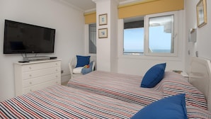 Una camera da letto con un letto, una televisione, una cassettiera e una finestra vista.