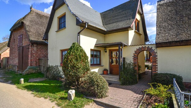 A traditional house with a steeply pitched roof, a brick chimney, and a well-maintained garden. - Beach front home in Mariendorf with WiFi (Mariendorf)