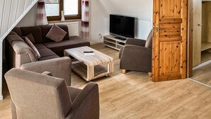 A cozy living room with a sectional sofa, a coffee table, and a TV. - Beach front home in Mariendorf with WiFi (Mariendorf)