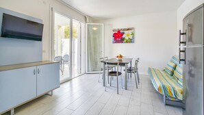 Een kleine keuken met een eethoek, een bank en een televisie.
