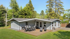 A small, single-story building with a covered patio area featuring outdoor furniture. - Pet friendly home in Væggerløse (Væggerløse)