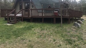A log cabin with a deck and stairs leading to the entrance. - Honey dome Hideout Unique cabin sitting on 5 acres in northern Michigan (Lewiston)