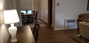 A dining area with a table and chairs, a lamp, a potted plant, and a radiator. - Charming Home In Quiet, Friendly Grangeville, Idaho Sleeps 9 Guests (Grangeville)