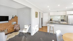Un appartamento moderno con zona soggiorno, cucina e sala da pranzo.