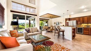 Un amplio espacio de sala con un sofá, una mesa de centro y vistas al exterior.