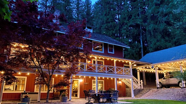 A two-story house with a covered porch and string lights.