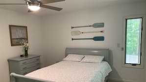 A bedroom with a bed, a dresser, a ceiling fan, a window, and two paddles on the wall. - Luxury Norris Lake Getaway - Perfect for Families & Groups - Lake Front w Dock! (Caryville)