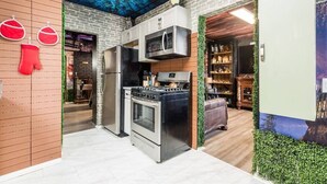A modern kitchen with stainless steel appliances, a wooden wall, and a ceiling mural. - ★McGonagall’s Mansion ★ Private Home w/ Arcade★ (Columbus)