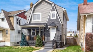 A two-story house with a front porch, a chimney, and a small front yard with a Christmas tree. - ★McGonagall’s Mansion ★ Private Home w/ Arcade★ (Columbus)