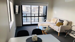 Un salon moderne avec un canapé, une table basse en verre et une table à manger.