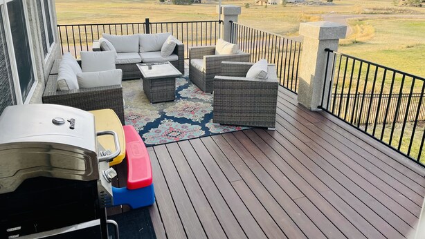 A deck with outdoor furniture, a grill, and a view of a residential area. - Massive Spacious House with Views, Adventure and Location (Colorado Springs)